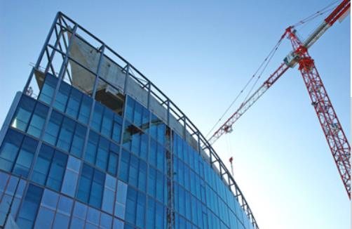 Façade vitrée en construction et grue